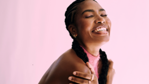Young woman smiling gently, practicing self-compassion and emotional self-care to prevent burnout.