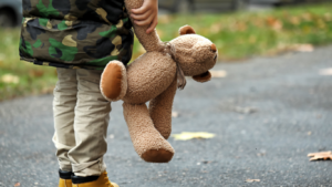 Little child holding teddy bear, symbolizing early attachment trauma contributing to adult anxiety